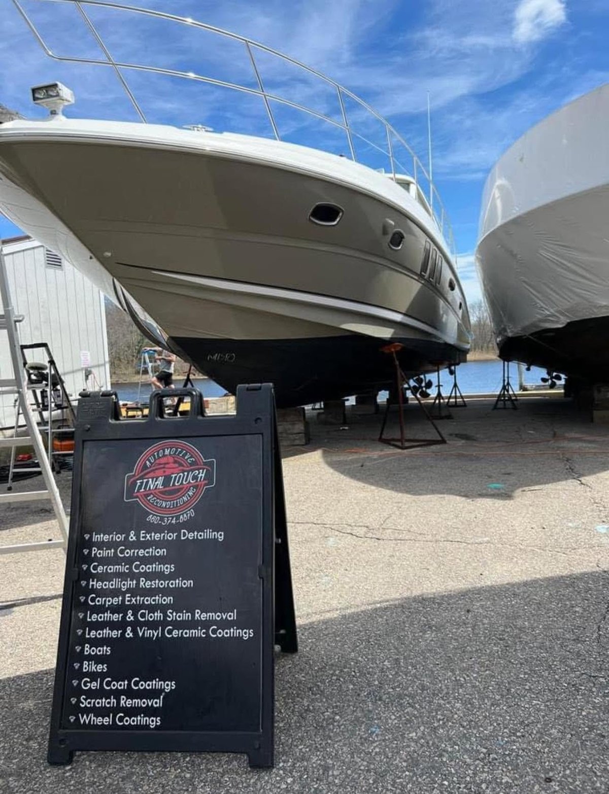 White boat on dry dock with The Final Touch service sign